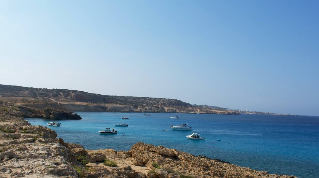 Blue Lagoon Cyprus — crystal clear turquoise water with boats anchored near Cape Greco