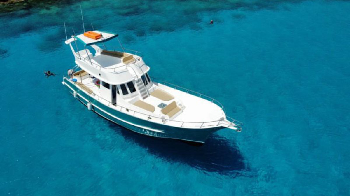 Fishing boat Ayia Napa aerial view crystal water Cyprus