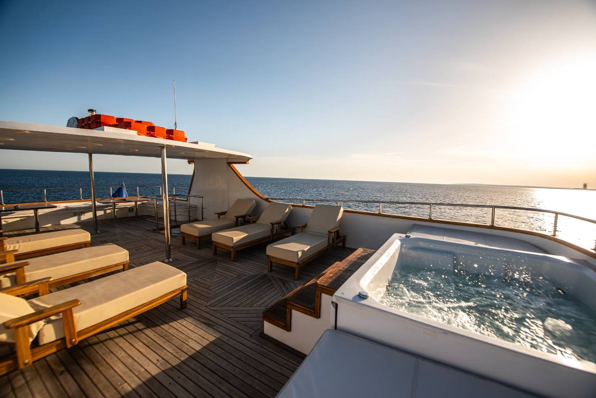 Ocean Queen sun deck with jacuzzi and loungers at sunset